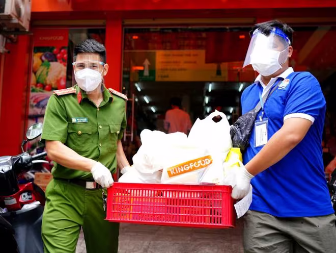 Chiến sĩ công an tham gia đi chợ mang hàng về trao tận tay người dân trong khu vực Vùng do dịch bệnh diễn biến rất phức tạp ở TP.HCM
