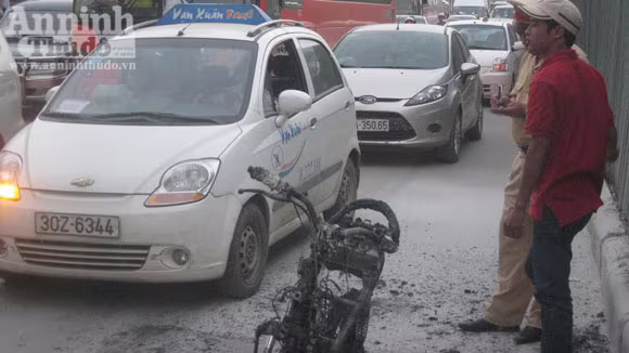 Chiếc xe bị thiêu rụi, trơ khung sắt được người dân khiêng vào vỉa hè