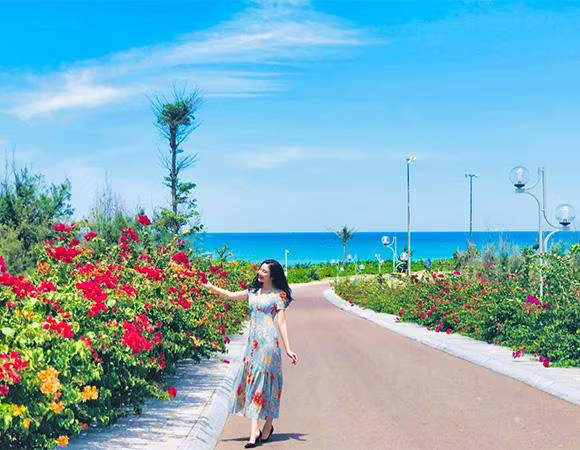 Con đường hoa giấy ven biển Nhơn Lý là góc check-in đẹp nức lòng với sắc hoa nổi bật trên background xanh ngọc của biển trời (Ảnh: Thảo Phùng)