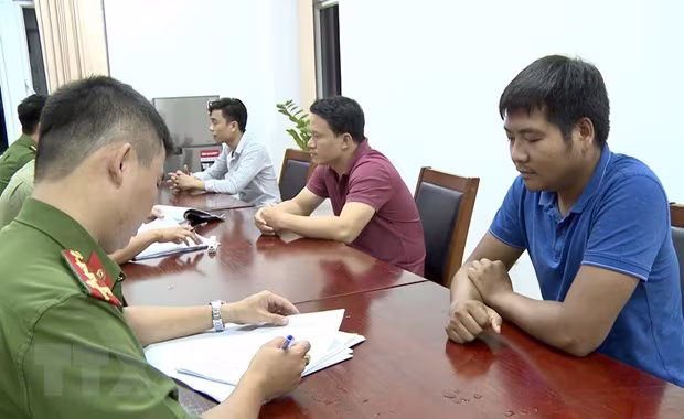 Lấy lời khai của nhóm đối tượng lừa đảo. Ảnh: TTXVN Lấy lời khai của nhóm đối tượng lừa đảo. Ảnh: TTXVN