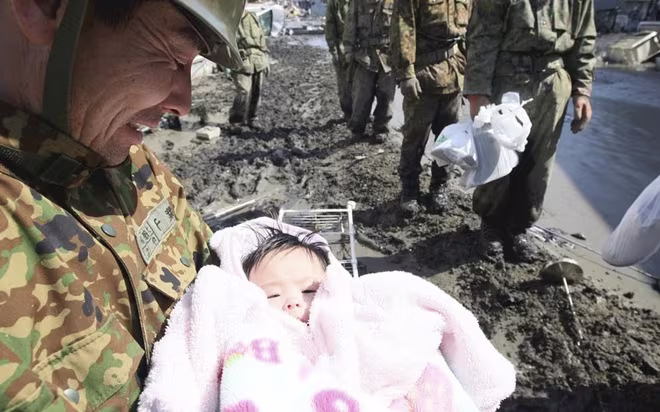 Thành viên Lực lượng Phòng vệ Nhật Bản bế em bé 4 tháng tuổi may mắn sống sót sau trận sóng thần ở thành phố Ishimaki, tỉnh Miyagi Thành viên Lực lượng Phòng vệ Nhật Bản bế em bé 4 tháng tuổi may mắn sống sót sau trận sóng thần ở thành phố Ishimaki, tỉnh Miyagi