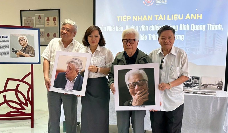 Nhà báo Ngô Minh Đạo (ngoài cùng bên phải) trao tặng Trung tâm Lưu trữ quốc gia III chân dung phóng viên ảnh chiến trường - Đinh Quang Thành và Trần Mai Hưởng.